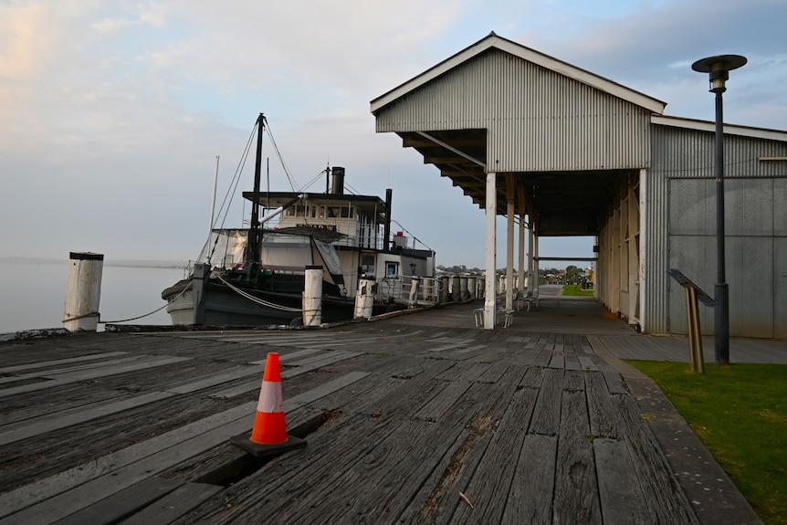 A wharf with a hole in it with a paddlesteam moored alongside