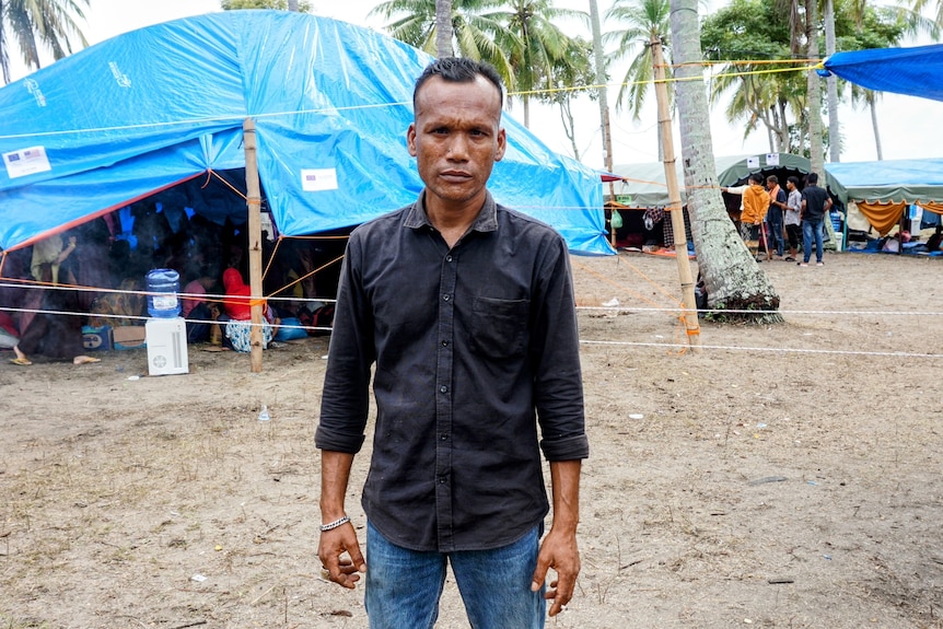 A man standing with a background of temporary tent
