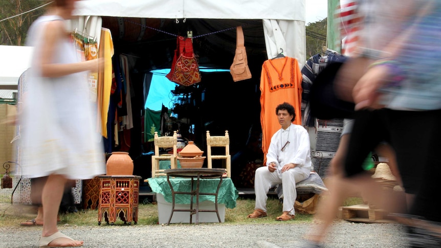 A stall owner watches the passing parade at the Woodford Folk Festival.