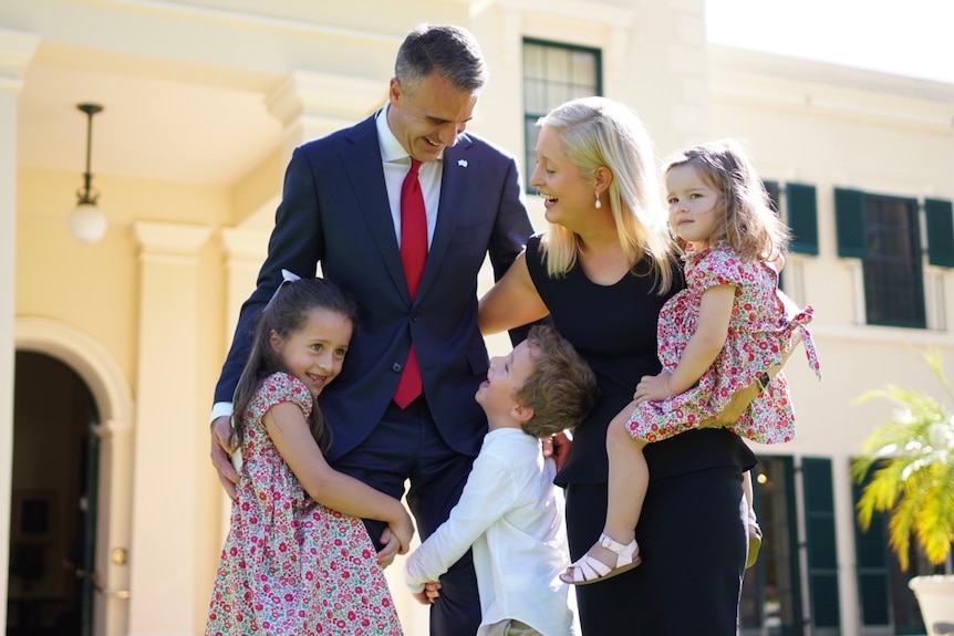 A man wearing a suit with a blonde woman and three children