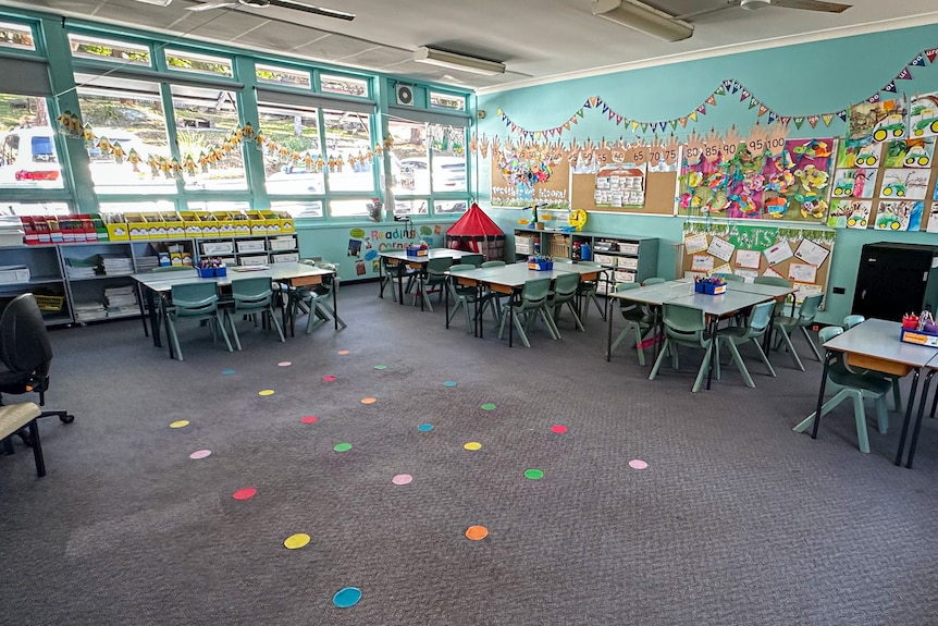 A brightly coloured, empty classroom for primary school students.