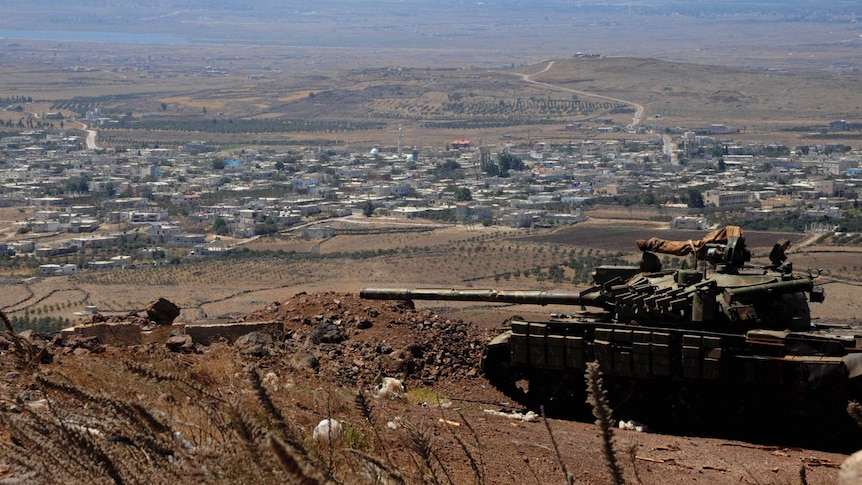 A tank loyal to Syrian president Bashar al-Assad seen near Quneitra city near the border fence with Israeli-occupied Golan Heights
