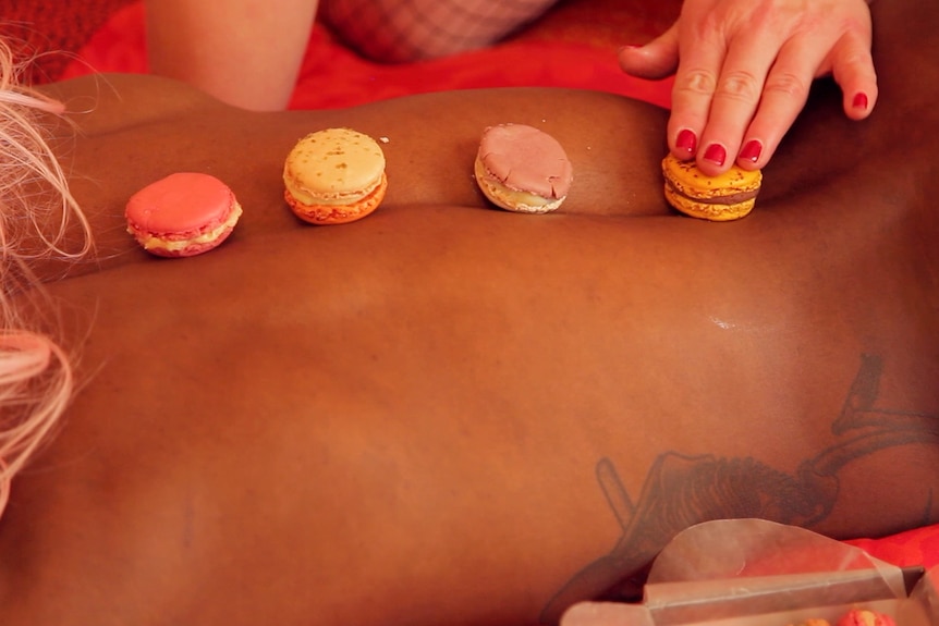 A back covered in macrons biscuits with a hand touching them