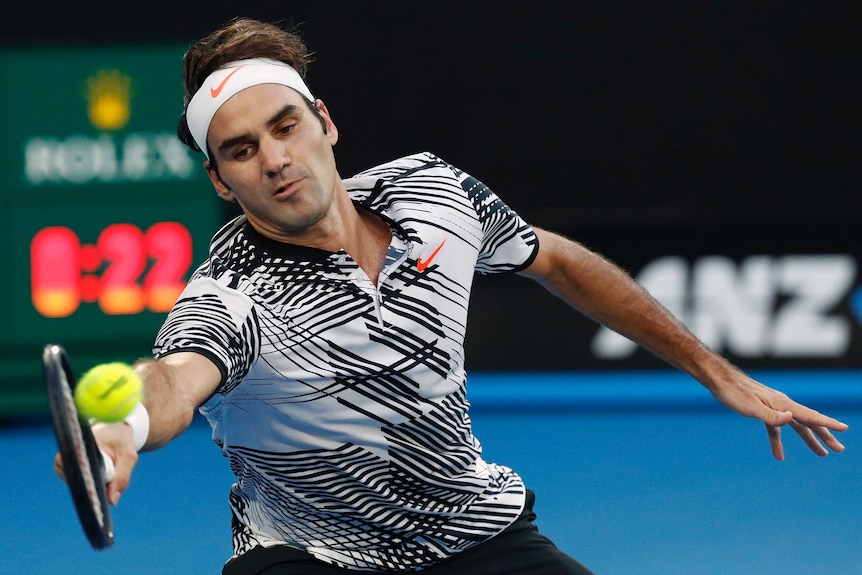 Rodger Federer lunges to reach tennis ball