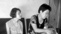 Two Chinese women sitting on a couch.