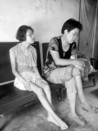 Two Chinese women sitting on a couch.