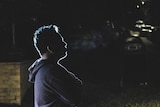 A profile shot of Bryan, with his face obscured in the dark, in a story about sibling abuse.