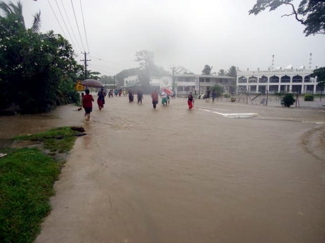People walk through floodwaters in Nadi