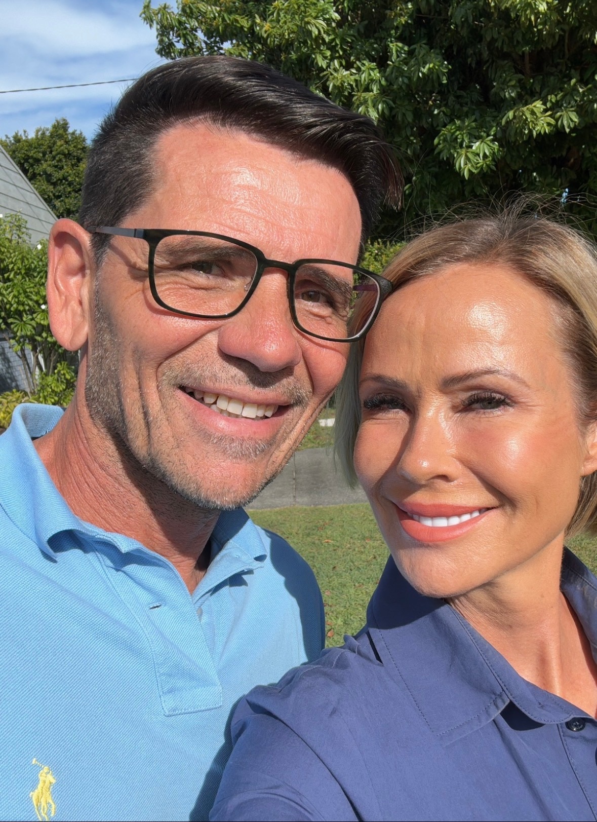 Un hombre y una mujer están uno cerca del otro y sonríen.