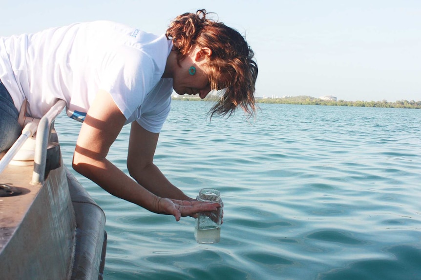 Jacqui Taylor takes a water sample from the Darwin Harbour oil slick.