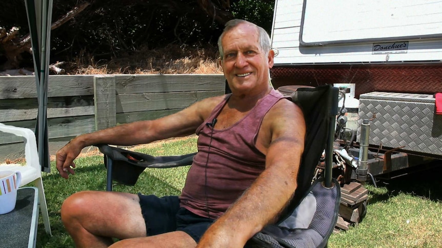 Portrait of longtime local to Warrnambool, Denis Hughson in his camping chair with caravan behind