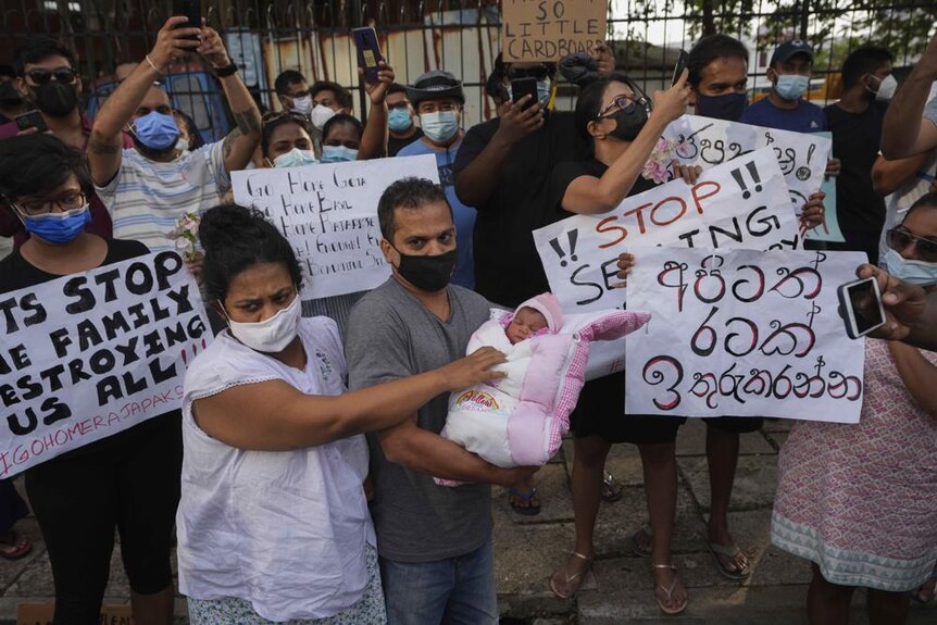 A Sri Lankan couple with their infant join an anti government protest during a curfew in Colombo, Sri Lanka.