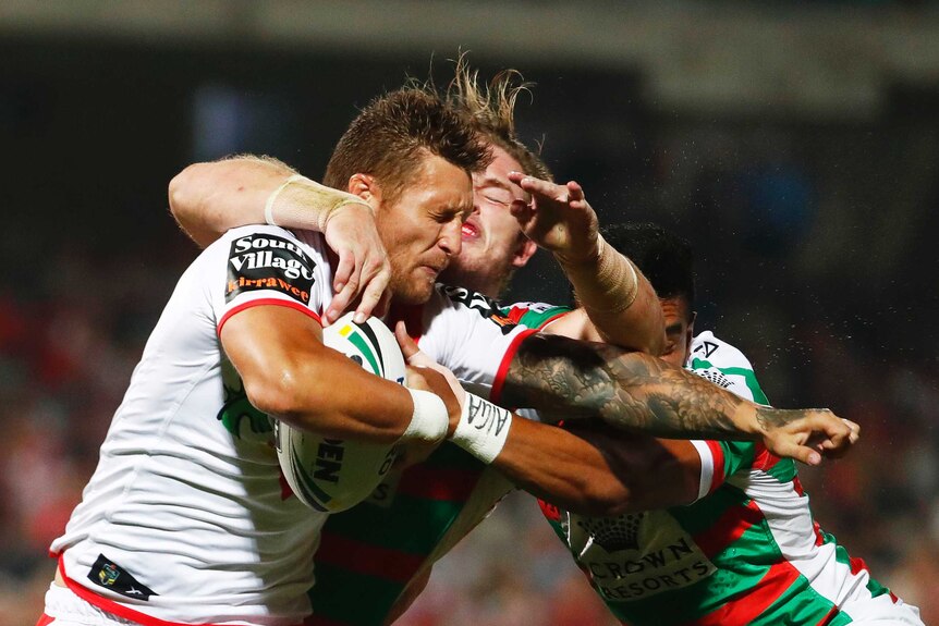Tariq Sims of the Dragons is tackled by South Sydney's George Burgess