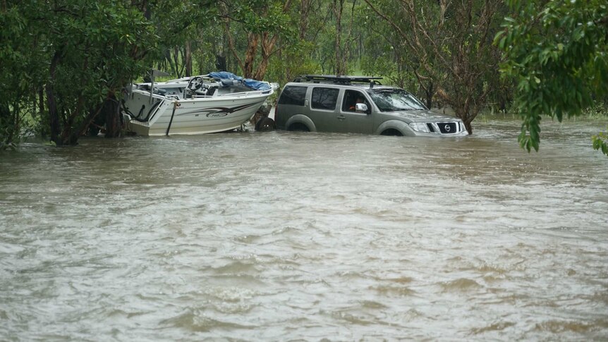 A four wheel drive towing a boat in water.