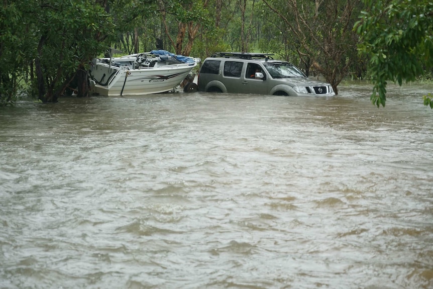 A four wheel drive towing a boat in water.