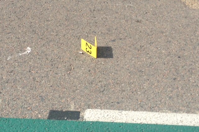 A bullet casing on the road near the service station.