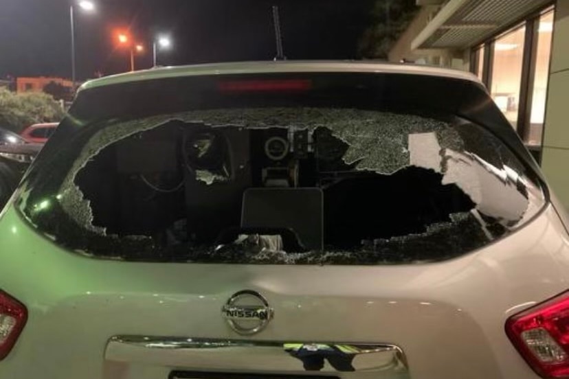 A white car with the rear window smashed in