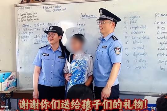 Мужчина и женщина в полицейской форме улыбаются рядом со студентом.