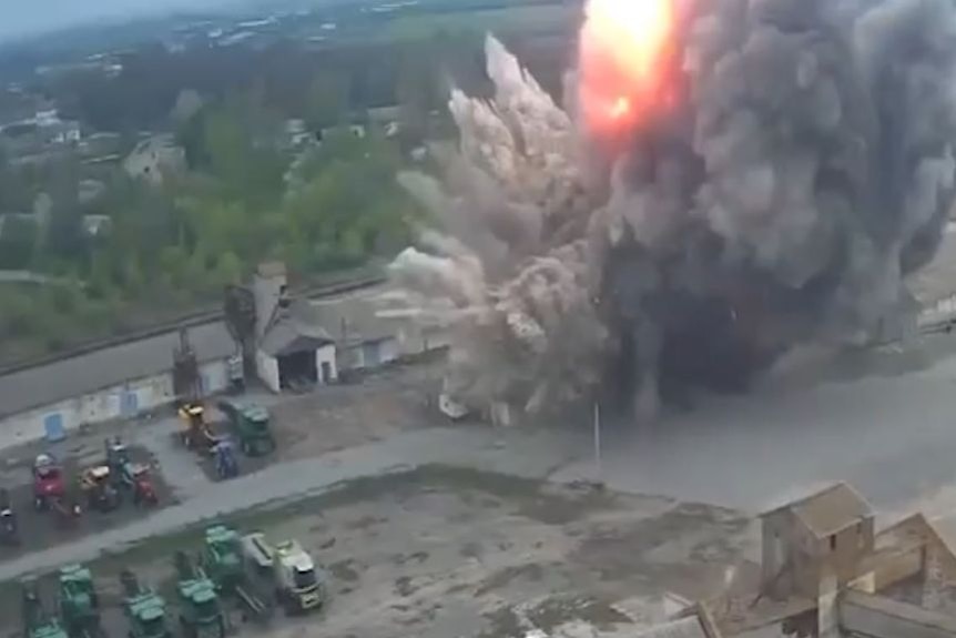 Aerial view of a fiery explosion at a grain storage facility, warehouses. 