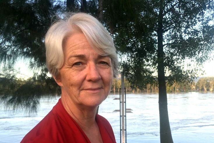 A woman stands in front of a river.