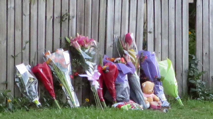 Flower tributes left near the house which is now a crime scene