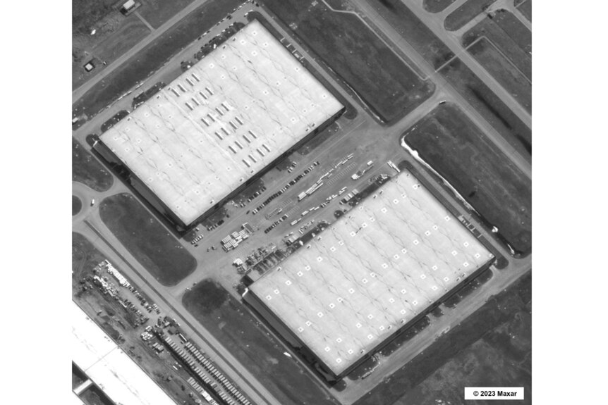 An aerial view of a large industrial facility, seen in greyscale