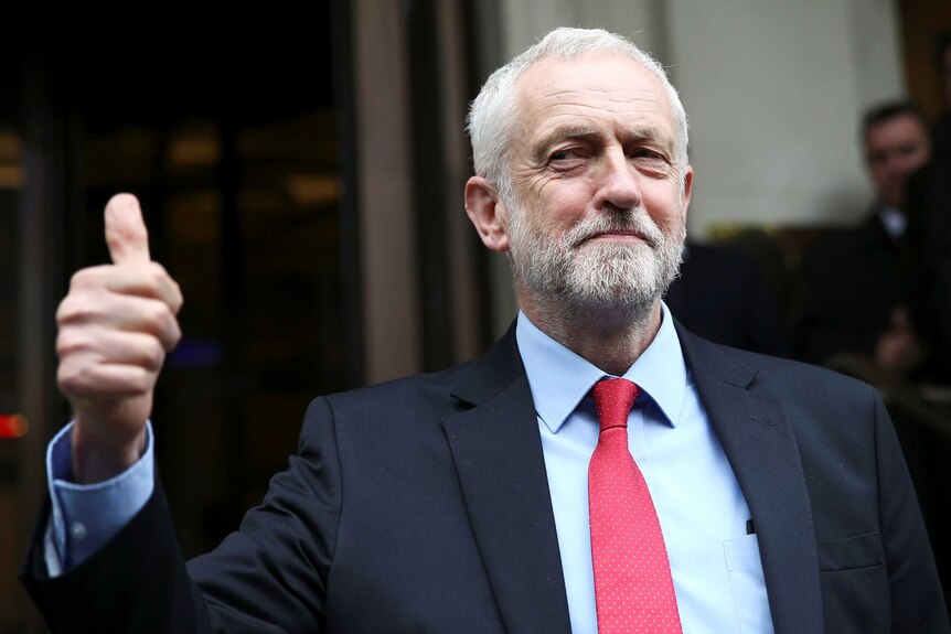 Jeremy Corbyn holds his thumb up.