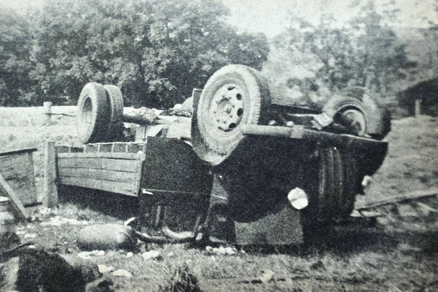 Black and white photo of truck on its side