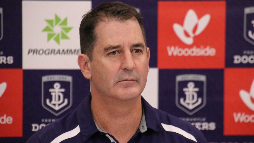 Ross Lyon looks at a reporter during the press conference.