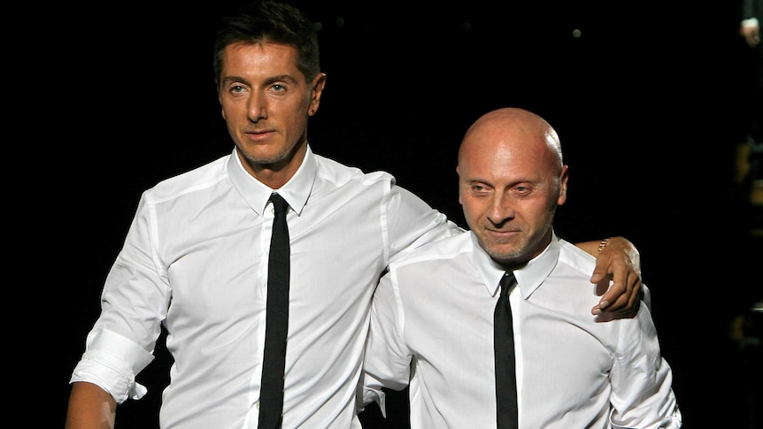 Domenico Dolce and Stefano Gabbana stand beside eachother in  matching white shirts and black ties.