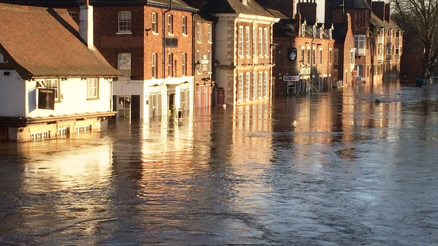 Floodwater lap at the eaves of buildings lining a street in the northern England city of York.