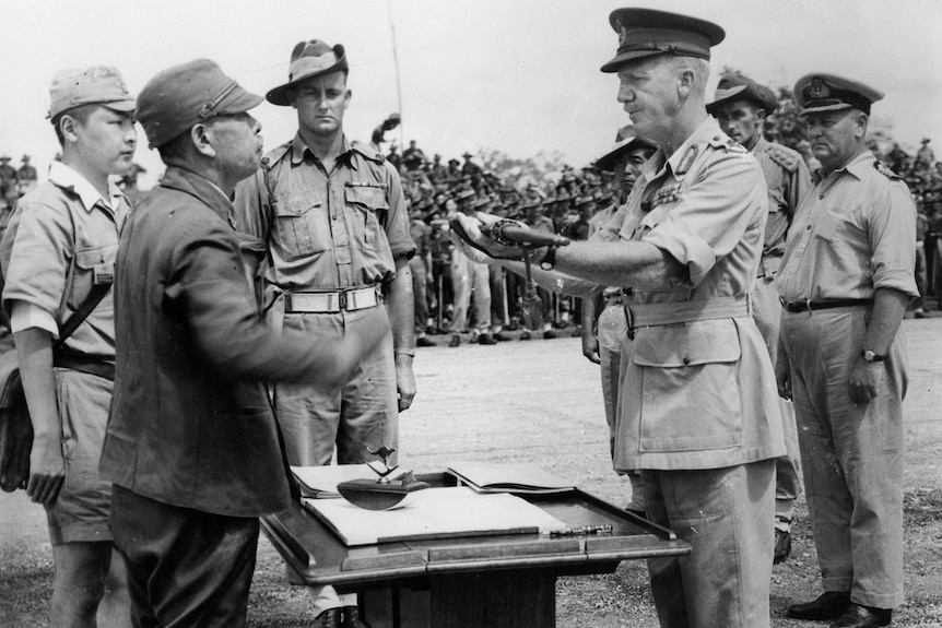 General Adachi surrenders his sword at the signing of the Japanese surrender in New Guines, september 13, 1945