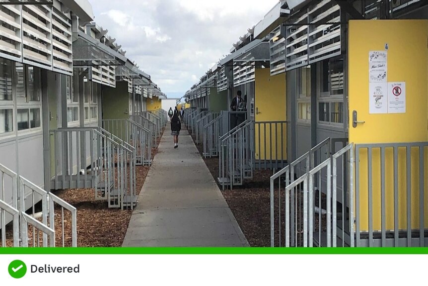 An exterior hallway lined by demountable buildings