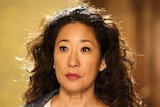 Sandra Oh, wearing a rain jacket, stares blankly ahead.
