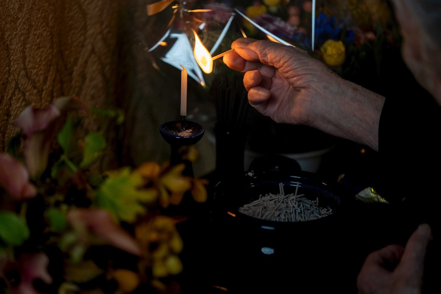 Setsuko lighting a candle at the shrine