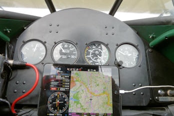 Cockpit of 1940s era biplane, with modern addition of satellite navigation.
