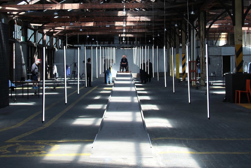 A warehouse with vertical hanging florescent lights in rows.