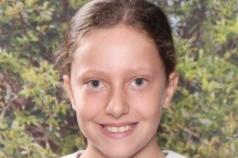 A young school girl wearing her uniform.