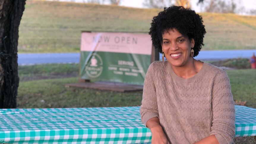 Whitney Plantation media manager Joy Banner sits at a picnic table smiling at the camera.