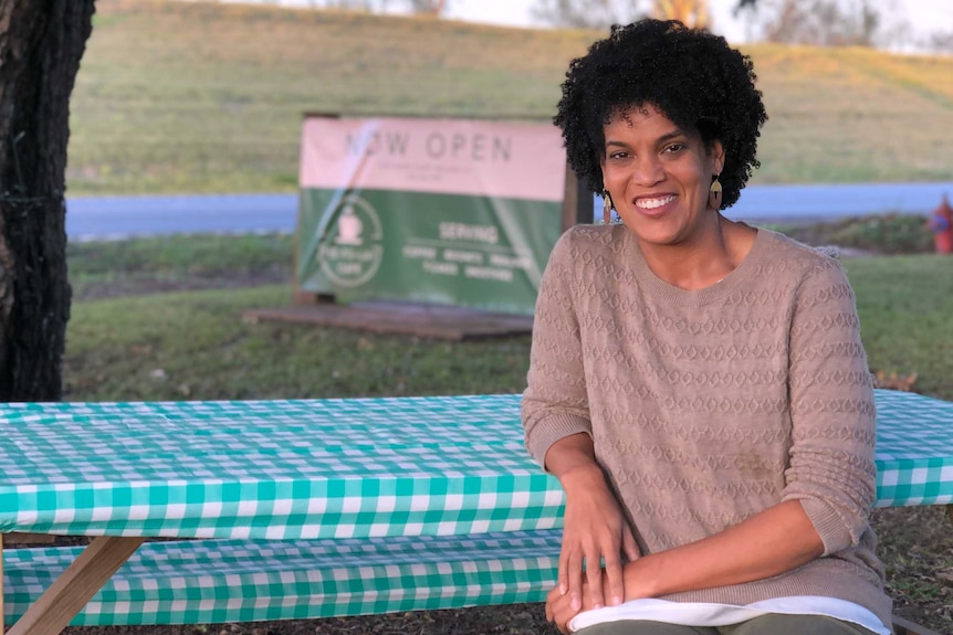 Whitney Plantation media manager Joy Banner sits at a picnic table smiling at the camera.