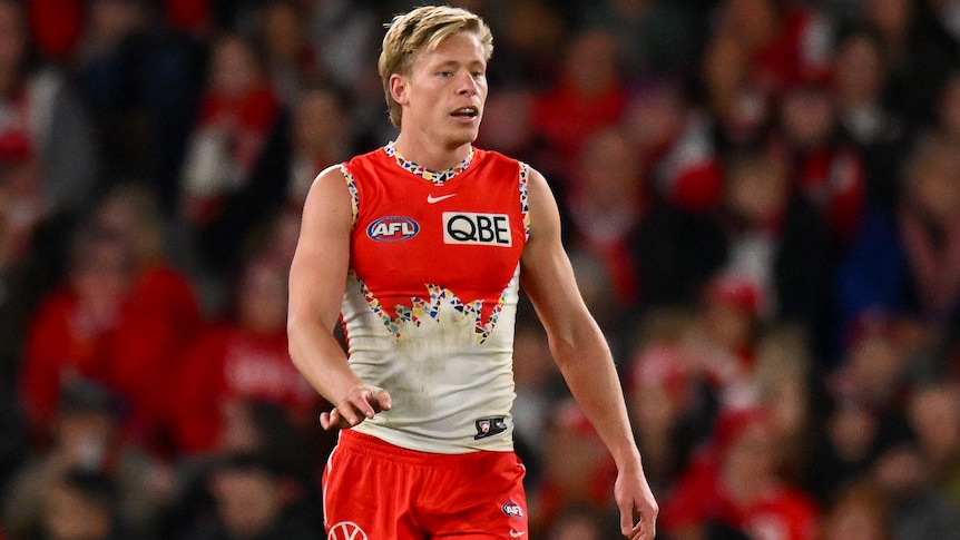 Isaac Heeney walking along the Docklands pitch during an AFL match.