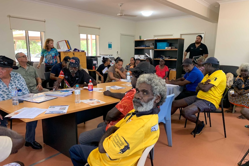 A room full of Indigenous leaders sits around a meeting table in a small office with NT Treat Commissioner Mick Dodson.