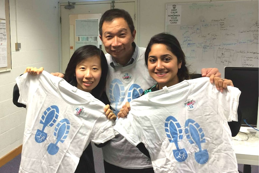 Ivy Tan and Chung Loh and Nashin Omar hold up the T-shirts they won as part of the UWA Activity Challenge.