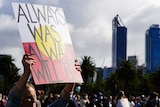 A woman holds up a sign saying 'always was, always will be' at a protest in Perth.
