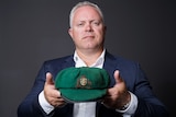Gavin Dempsey, executive manager of auction house Pickles, holds Sir Donald Bradman's first baggy green cap.