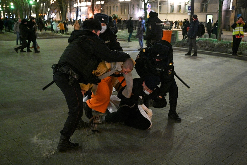 Police officers detain demonstrators in Moscow.