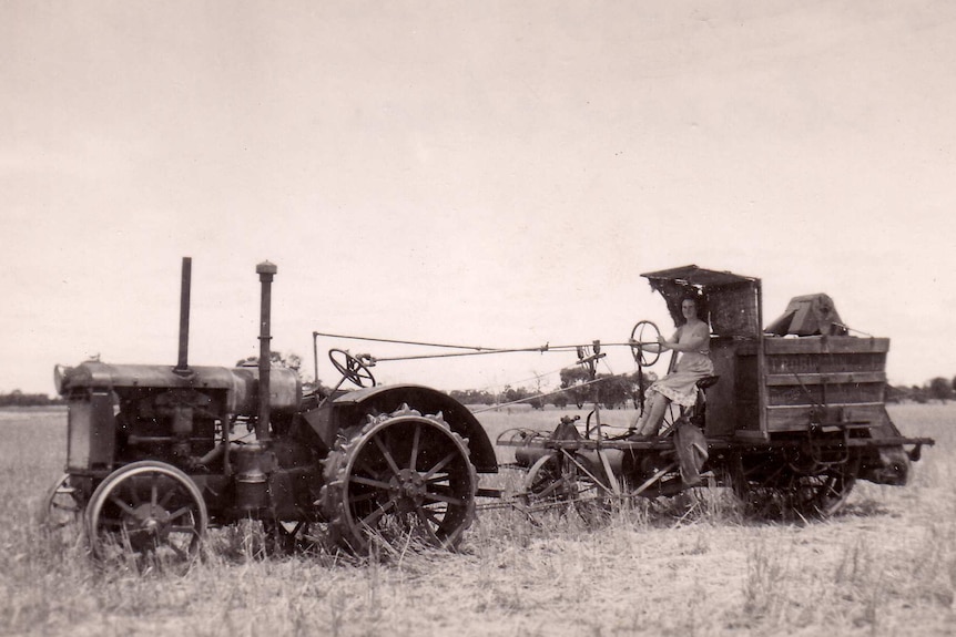 Black and white photo of a woman driving a tractor