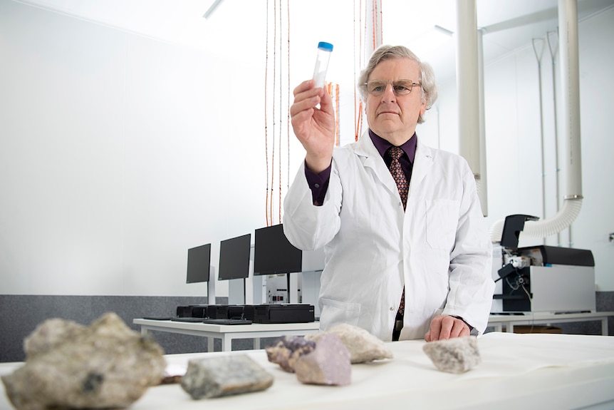 A chemist holds up a specimen.