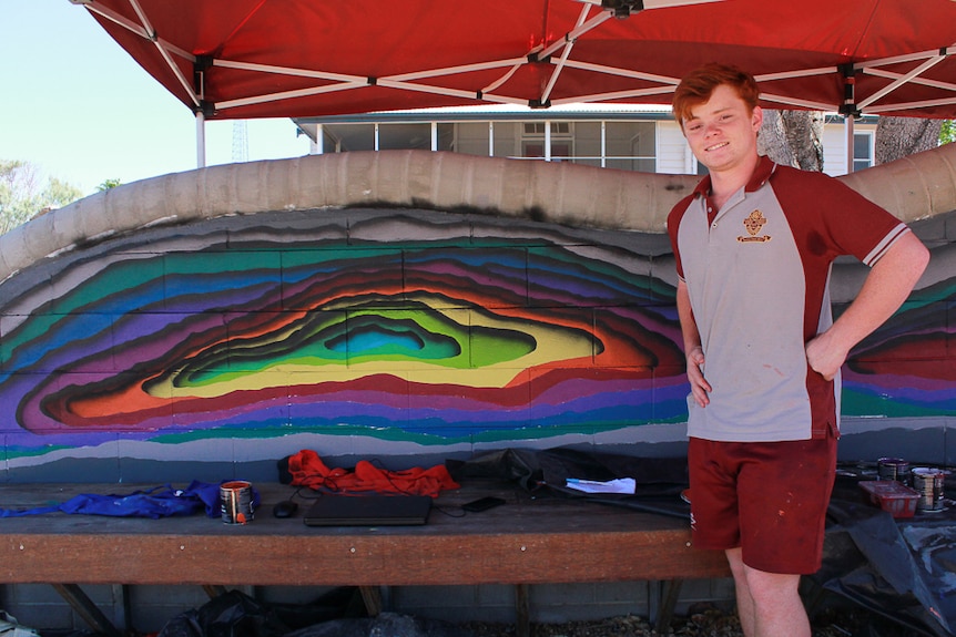 Chris Read in front of the Hughenden State School mural which he helped designed