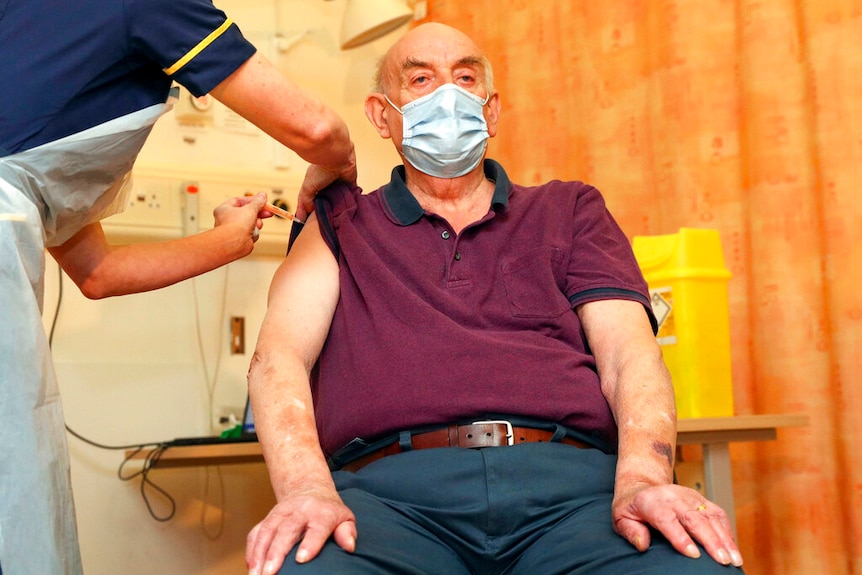 82-year-old Brian Pinker receives the Oxford University/AstraZeneca COVID-19 vaccine from nurse.